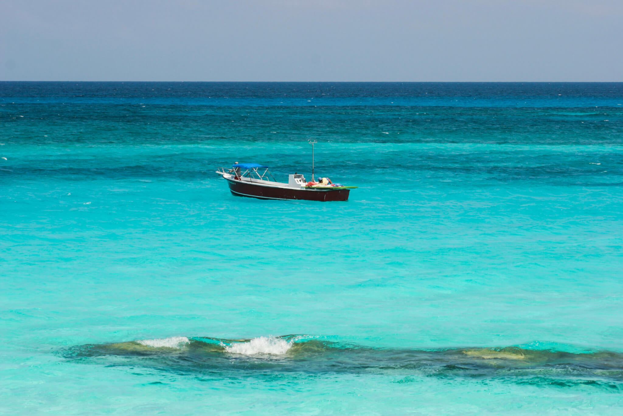 Small fishing boat anchored in turquoise waters