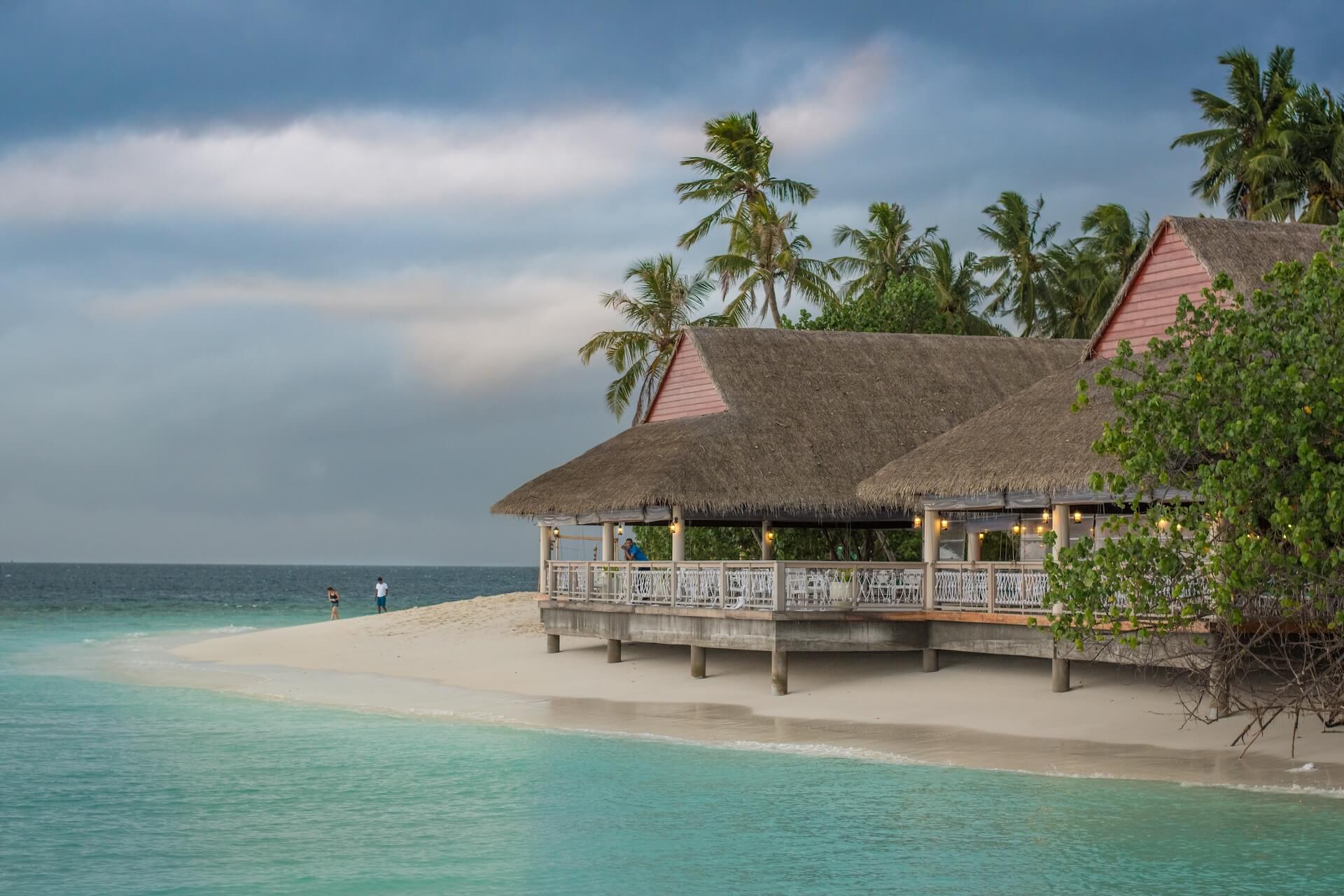 A large hut on the beach just over the turquoise waters