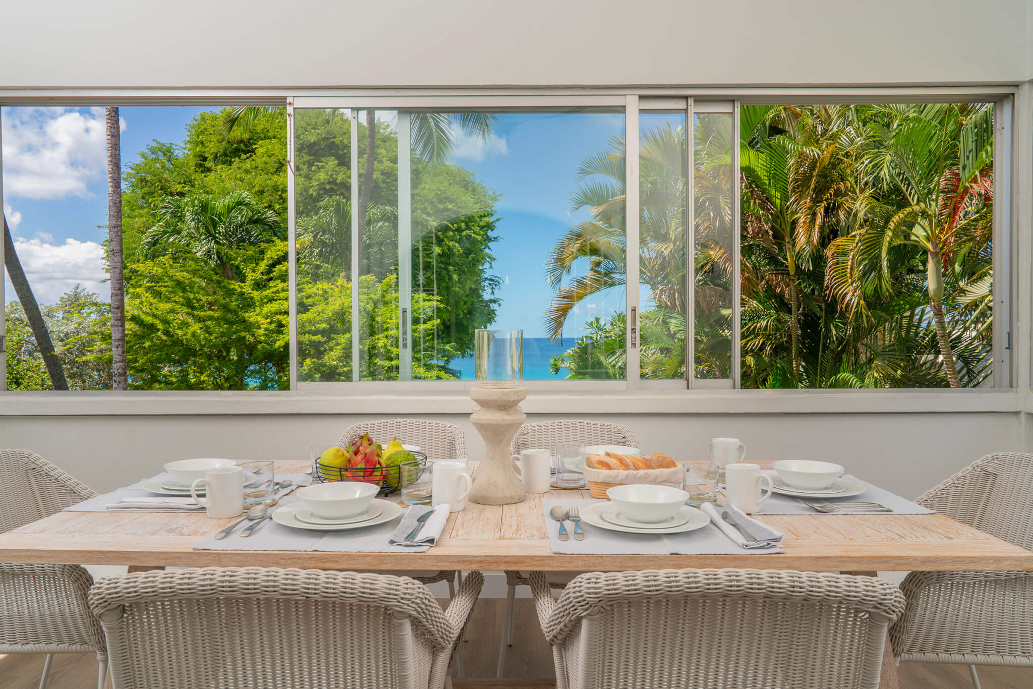 Dining room with a table neatly laid for six with views over the Atlantic ocean