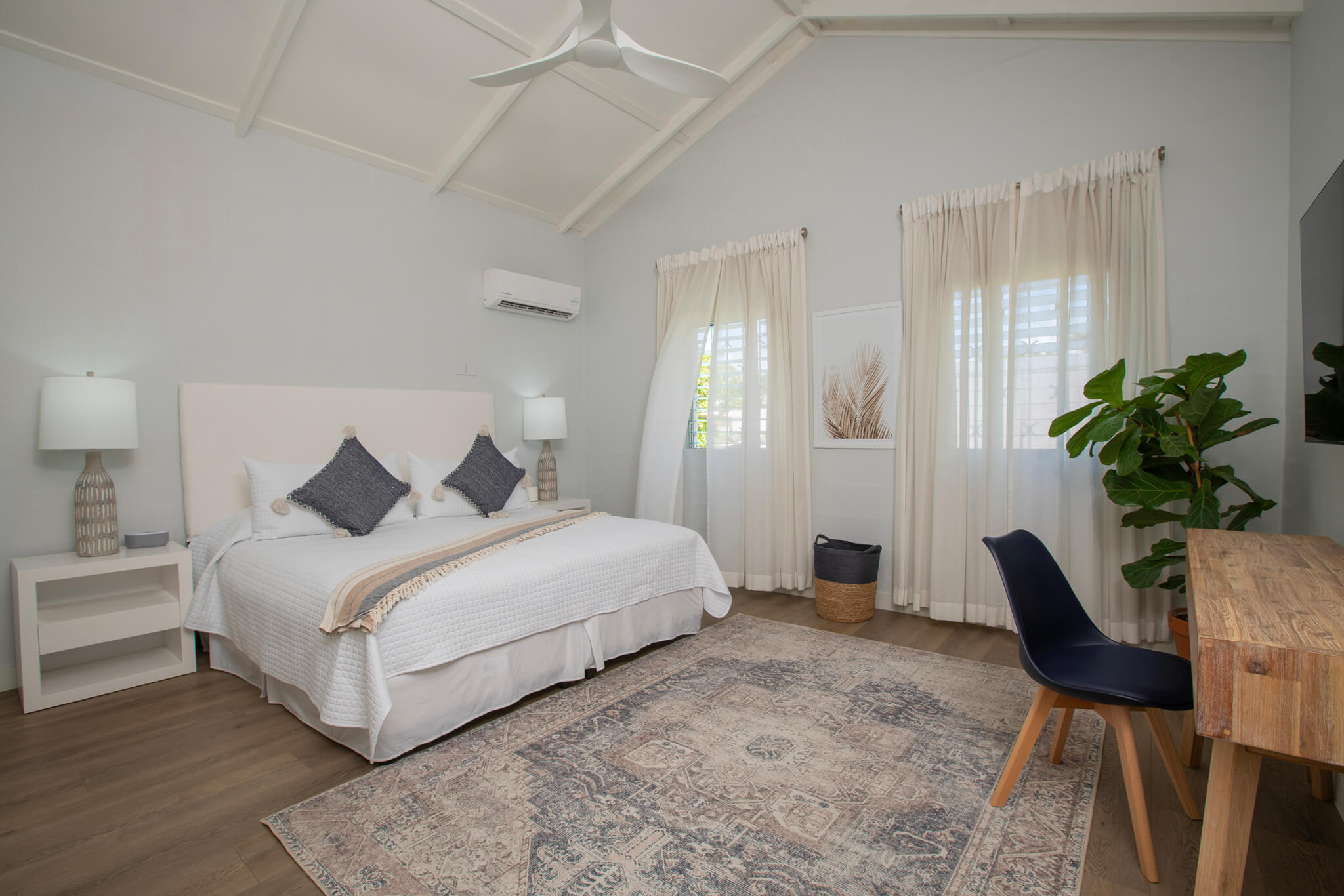 Master bedroom with a large bed and a vanity table as well as a large Persian style rug